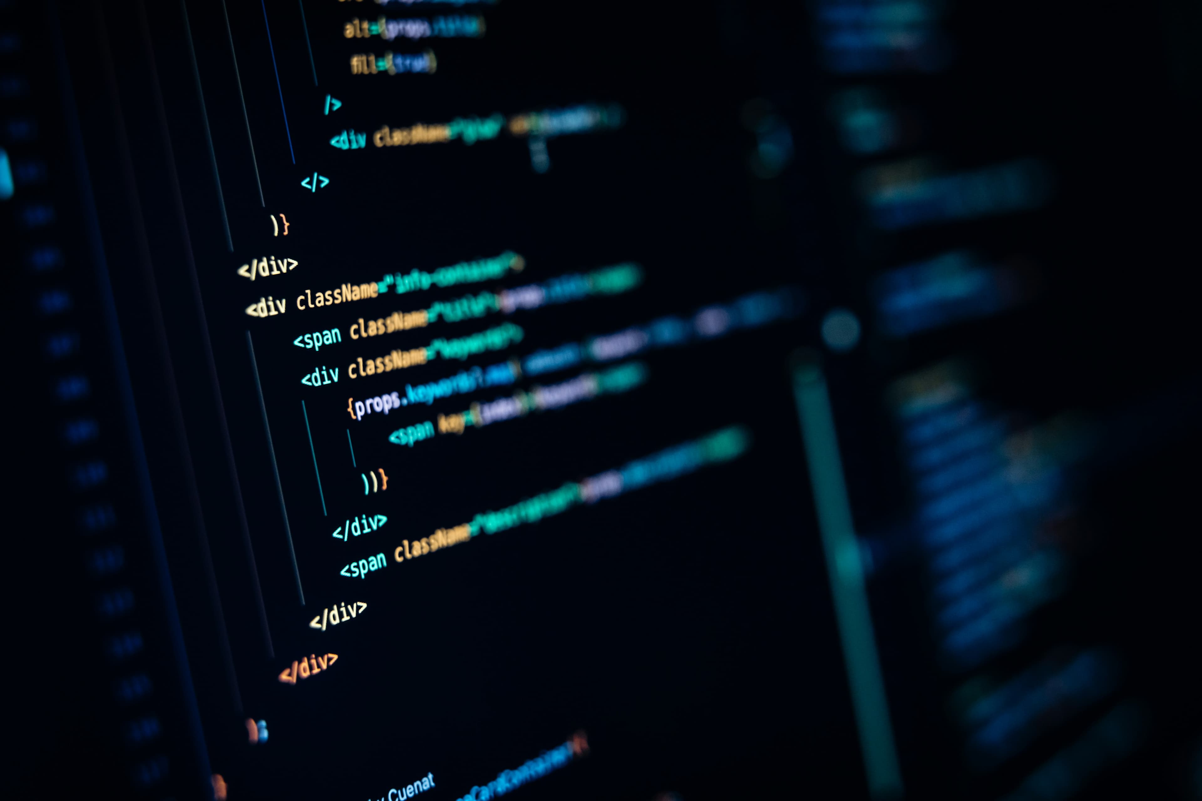 A dark close-up of a computer monitor displaying many lines of code